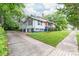 Side view of the home featuring an ample yard and sunroom addition at 319 S Oakland St, Gastonia, NC 28052