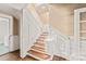 Elegant staircase with white wainscoting and wooden steps, adjacent to a laundry area at 319 S Oakland St, Gastonia, NC 28052