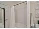 Clean bathroom featuring white tile, shower and bathtub combination, and wall art at 400 N Church St # 226, Charlotte, NC 28202