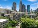 A vibrant city view featuring lush green trees lining the streets and modern architecture against a bright blue skyline at 400 N Church St # 226, Charlotte, NC 28202