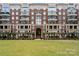 Stunning exterior view of a brick condo building showcasing balconies and a well-manicured lawn at 400 N Church St # 226, Charlotte, NC 28202