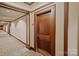 Hallway with patterned carpet, wood trim and doors; uniform lighting creates an inviting and accessible space at 400 N Church St # 226, Charlotte, NC 28202