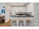 Modern kitchen featuring white cabinets, granite countertops, stainless steel appliances, and a breakfast bar with stools at 400 N Church St # 226, Charlotte, NC 28202