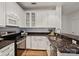 Modern kitchen featuring stainless steel appliances, granite countertops, and white cabinets with glass display at 400 N Church St # 226, Charlotte, NC 28202