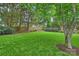 Beautiful backyard featuring lush lawn, mature trees, and manicured landscaping, providing a private and serene outdoor space at 5508 Kincross Ln, Charlotte, NC 28277