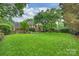 Large backyard with a well-maintained lawn, mature trees, and patio area, ideal for outdoor living at 5508 Kincross Ln, Charlotte, NC 28277