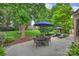 Serene backyard featuring a patio with outdoor seating, mature trees, and lush green grass at 5508 Kincross Ln, Charlotte, NC 28277