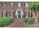 Inviting front entrance with brick steps, black door, and manicured greenery, creating a welcoming first impression at 5508 Kincross Ln, Charlotte, NC 28277