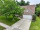 Aerial view of a brick home featuring a driveway, two-car garage and large front lawn with mature trees at 5656 Cambridge Bay Dr, Charlotte, NC 28269