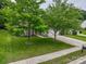 Overhead image of a brick home showcasing its well-kept lawn, driveway, and mature trees on a clear day at 5656 Cambridge Bay Dr, Charlotte, NC 28269