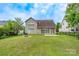 Exterior home view showcasing large yard, patio, sunroom, and firepit at 5656 Cambridge Bay Dr, Charlotte, NC 28269