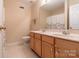 Bright bathroom featuring double vanity, tile floor, neutral paint, and shower with floral curtain at 5656 Cambridge Bay Dr, Charlotte, NC 28269