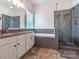 A luxurious bathroom features a large soaking tub and glass shower at 5656 Cambridge Bay Dr, Charlotte, NC 28269