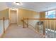 Spacious hallway with carpet and wood trim featuring a view to the downstairs foyer at 5656 Cambridge Bay Dr, Charlotte, NC 28269