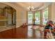 Sunlit living room showcasing beautiful hardwood floors, a chandelier, and large bay windows at 5656 Cambridge Bay Dr, Charlotte, NC 28269