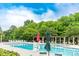 Community pool surrounded by trees, lounge chairs, tables and umbrellas for relaxing by the water at 5656 Cambridge Bay Dr, Charlotte, NC 28269