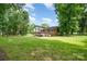 Spacious backyard featuring a well-maintained lawn, mature trees, and the home's back exterior with an attached deck at 5772 Gettysburg Nw Dr, Concord, NC 28027
