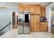 Spacious kitchen featuring a stainless steel refrigerator, ample wood cabinet space, and marble-look floors at 5772 Gettysburg Nw Dr, Concord, NC 28027