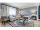 Cozy living room with gray sofas, a patterned rug, and natural light from large windows at 5772 Gettysburg Nw Dr, Concord, NC 28027
