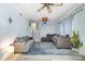 Comfortable living room with a ceiling fan, a projector, neutral sofas, a patterned rug, and staircase at 5772 Gettysburg Nw Dr, Concord, NC 28027