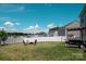 A spacious backyard includes a manicured lawn, privacy fence, fire pit with Adirondack chairs, and a grill at 5812 Camp Sw Ct, Concord, NC 28025