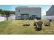 Backyard includes a manicured lawn, privacy fence, fire pit with Adirondack chairs, a grill, and patio at 5812 Camp Sw Ct, Concord, NC 28025