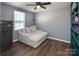 Bedroom features a soft grey accent wall with cozy lounge seating and a built-in bookcase against wood floors at 5812 Camp Sw Ct, Concord, NC 28025