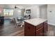 Stylish kitchen island with granite countertops and hardwood flooring, seamlessly flowing into the living area at 5812 Camp Sw Ct, Concord, NC 28025