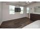 Open main bedroom with hardwood floors, three windows, and large dresser at 5812 Camp Sw Ct, Concord, NC 28025