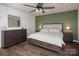 Stylish main bedroom featuring a green accent wall, ceiling fan, and wood-look floors at 5812 Camp Sw Ct, Concord, NC 28025