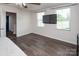 Sunlit main bedroom with wood floors, television, and open doorway at 5812 Camp Sw Ct, Concord, NC 28025