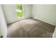 Empty bedroom with neutral carpet, a bright window, and fresh paint at 6041 Misty Way Ln, Charlotte, NC 28212