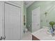 A half bathroom features mint green walls, white trim, hexagon tile flooring, and a vanity with a white countertop at 617 Peace Haven Rd, Kannapolis, NC 28083