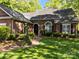 A brick home features a mature landscape, a brick walkway and driveway, and a covered porch with an arched entryway at 617 Peace Haven Rd, Kannapolis, NC 28083
