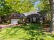 A traditional brick home features a manicured lawn, mature trees, a driveway, and a two car garage at 617 Peace Haven Rd, Kannapolis, NC 28083