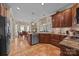 An eat-in kitchen boasts stainless steel appliances, wood cabinetry, terra cotta flooring, and granite countertops at 617 Peace Haven Rd, Kannapolis, NC 28083