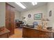 A home office offers hardwood flooring, wood trim, and a large desk with decorative lamps and organizers at 617 Peace Haven Rd, Kannapolis, NC 28083