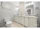 Well-lit bathroom with a toilet and a double vanity with a tower storage in the middle at 64 Timberidge Dr, Lake Wylie, SC 29710