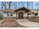 Charming home entrance featuring a stone facade, covered porch, and a beautiful dark wood front door with decorative glass at 64 Timberidge Dr, Lake Wylie, SC 29710