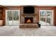 Spacious living room with a cozy brick fireplace, wood paneling, and sliding glass doors to deck at 64 Timberidge Dr, Lake Wylie, SC 29710