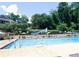Outdoor swimming pool with lane markers, lounge chairs, and mature trees around the perimeter at 64 Timberidge Dr, Lake Wylie, SC 29710