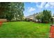 A backyard featuring a lush green lawn, a patio set, and well-maintained landscaping for outdoor enjoyment at 6717 Bickham Ln, Charlotte, NC 28269