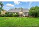 Beautiful backyard with a large lawn, a patio area with seating, and meticulous landscaping for outdoor living at 6717 Bickham Ln, Charlotte, NC 28269