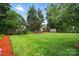 Lush backyard with manicured lawn, mature trees, and plenty of space for outdoor activities at 6717 Bickham Ln, Charlotte, NC 28269