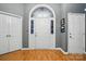Bright foyer with hardwood floors, white front door with sidelights, and two white closet doors at 6717 Bickham Ln, Charlotte, NC 28269