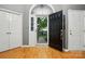Spacious foyer with hardwood floors, a black front door, and two white closet doors, creating an inviting entrance at 6717 Bickham Ln, Charlotte, NC 28269