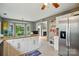 Open-concept kitchen with white cabinets, granite countertops, stainless steel refrigerator, and backyard views at 6717 Bickham Ln, Charlotte, NC 28269