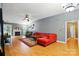 Open living room with high ceilings, hardwood floors, fireplace, and a comfortable red sectional sofa at 6717 Bickham Ln, Charlotte, NC 28269