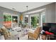Bright sunroom featuring large windows, three chairs with floral design, and a decorative table for plants at 6717 Bickham Ln, Charlotte, NC 28269