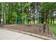 Charming swing set nestled among mature trees on a mulched surface, creating a tranquil outdoor space at 6717 Bickham Ln, Charlotte, NC 28269